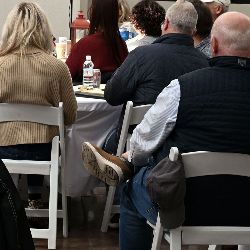 A corporate team seated at round tables in the Grand White Barn at Cedar Pond Farms.