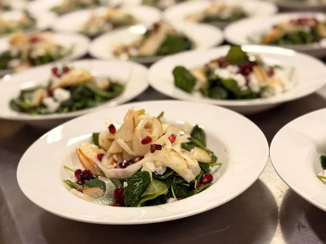 Rows of plated salads ready to serve at a corporate dinner in the Grand White Barn.
