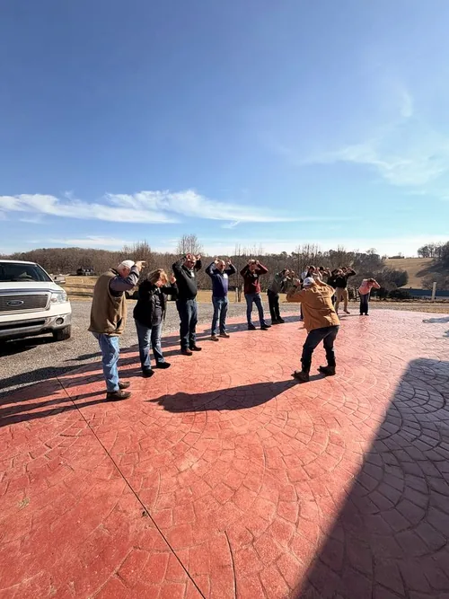 A team-building game on the stamped patio at Cedar Pond Farms under a blue winter sky.