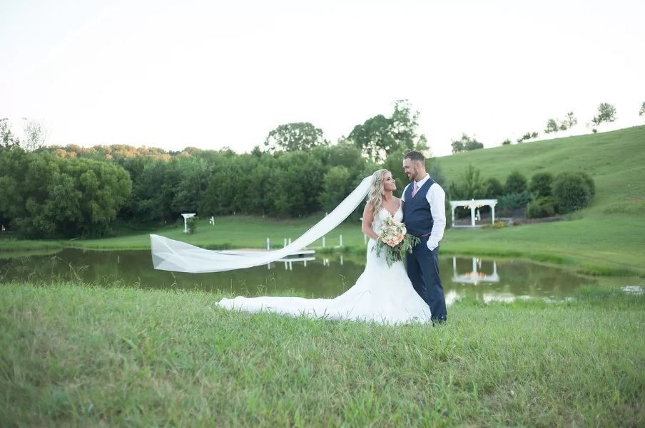 A bride and groom in The Little Meadow, an open grassy clearing above the pond