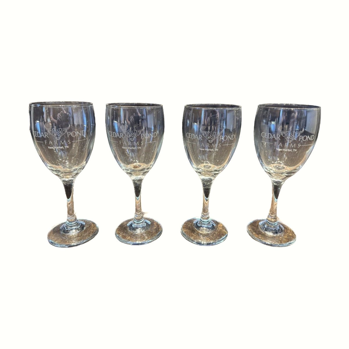 Set of four clear stemmed wine glasses etched with the Cedar Pond Farms bull logo and New Market, TN text.