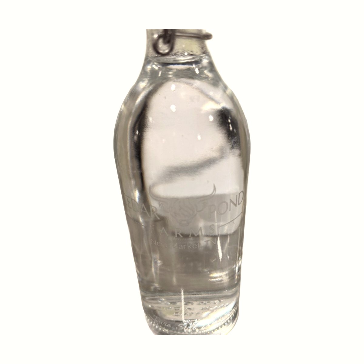 Clear glass bottle with wire-latch cap, embossed with the Cedar Pond Farms logo and 'New Market, TN'.
