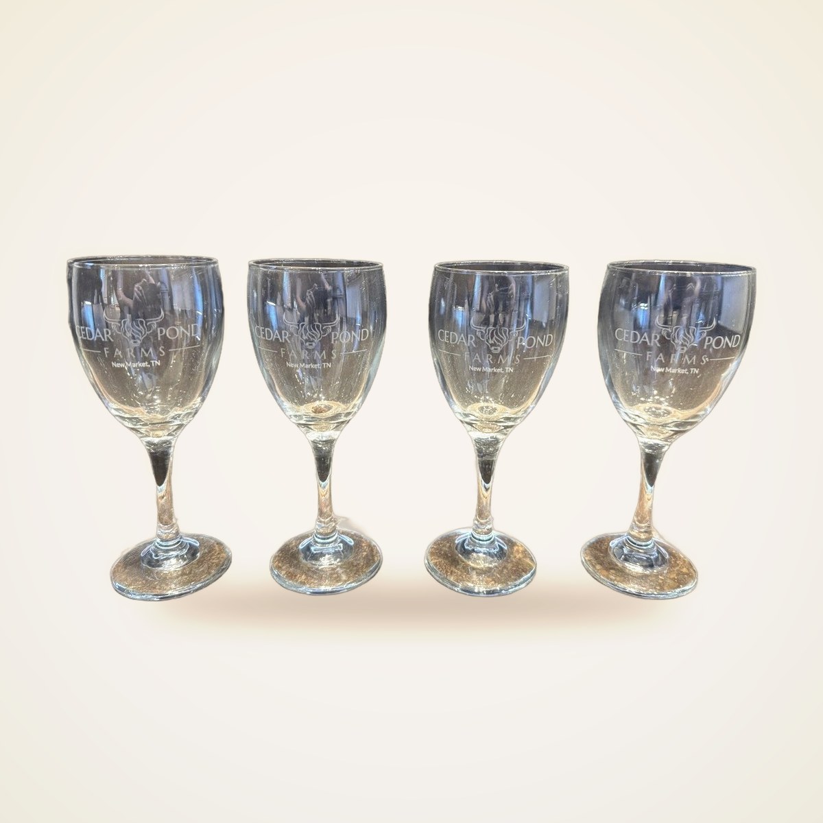 Set of four clear stemmed wine glasses etched with the Cedar Pond Farms bull logo and New Market, TN text.