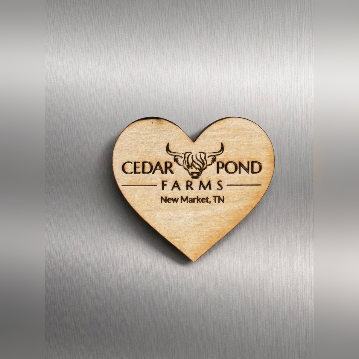 Wooden heart-shaped magnet engraved with Cedar Pond Farms logo, highland cow, and New Market, TN text
