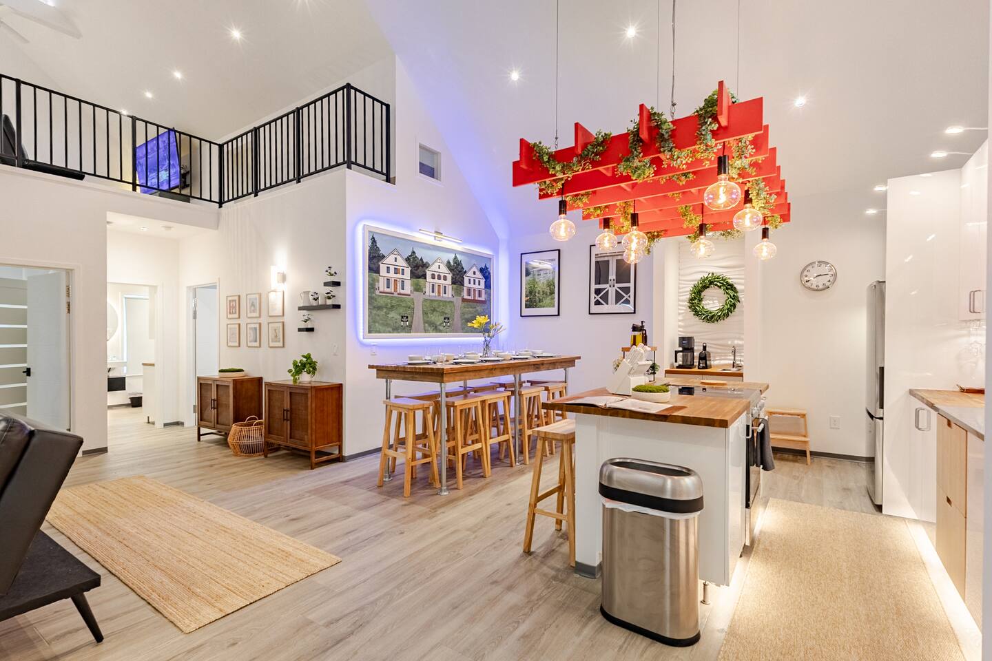 Bright open kitchen with loft overlook, island seating, and stylish dining space