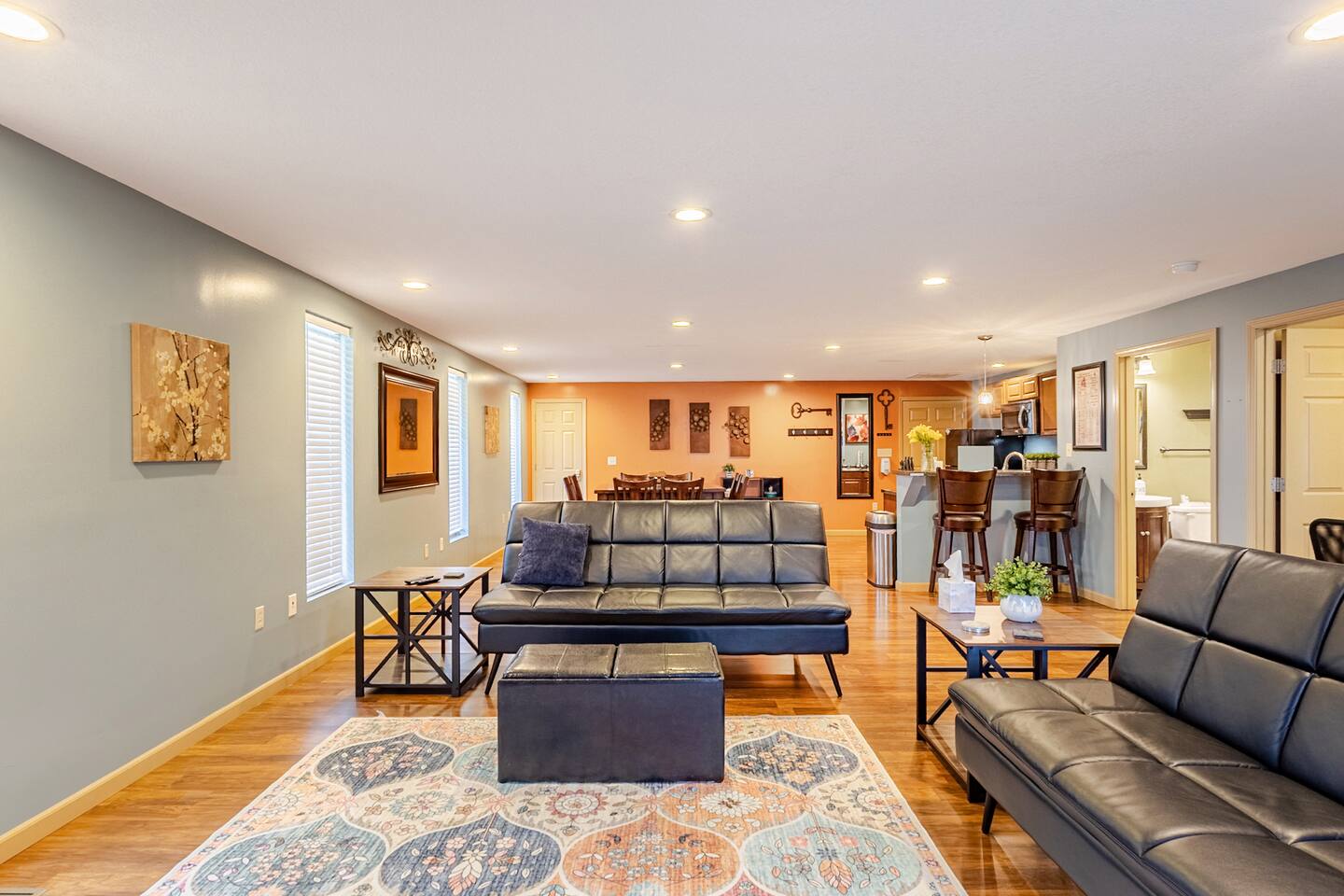 Spacious open living area with comfy seating, dining space, and breakfast bar