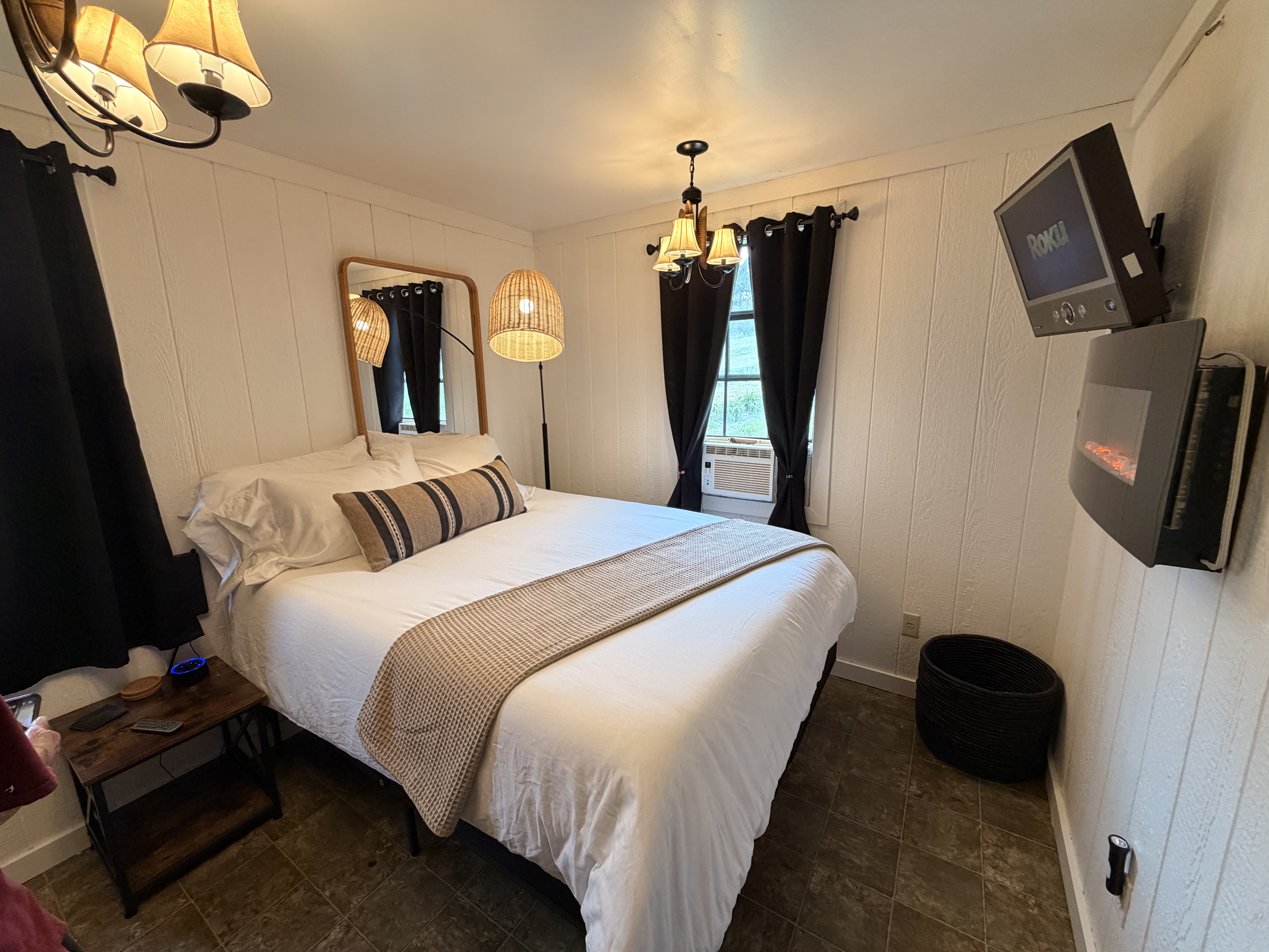 Cozy queen bedroom with fireplace, TV, and warm modern touches